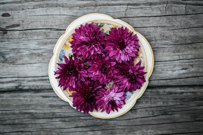 白色陶瓷盘上有粉红色花瓣的花